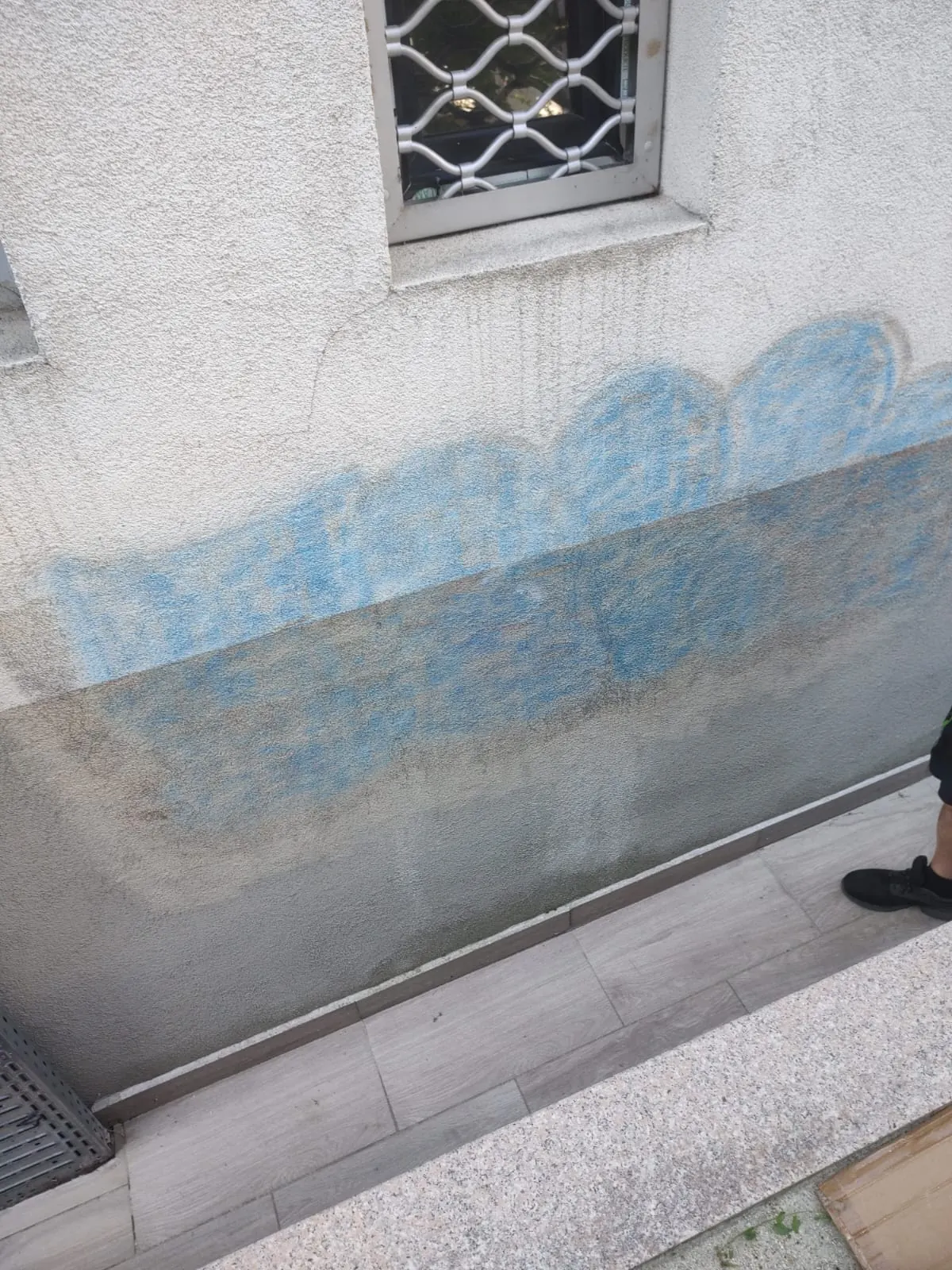 Același perete — jumătate încă intactă, jumătate deja curățată de laser